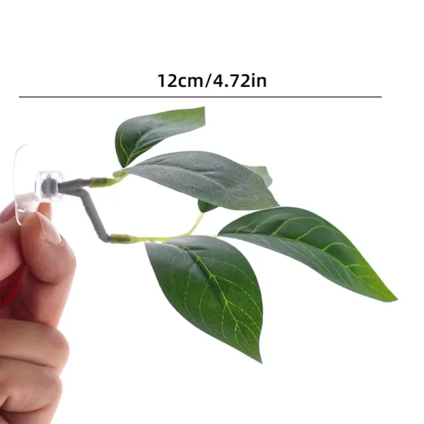 Plante artificielle d'aquarium verte en plastique, tenue par une main et ventouse transparente.