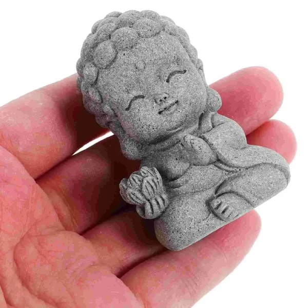 Statue Bouddha enfant en gris résine, méditant, tenant fleur de lotus.
